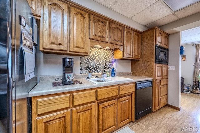 23598 Falcon Rd, Lebanon, MO 65536 - kitchen with black appliances, a sink, light wood-style flooring, light countertops, and decorative backsplash