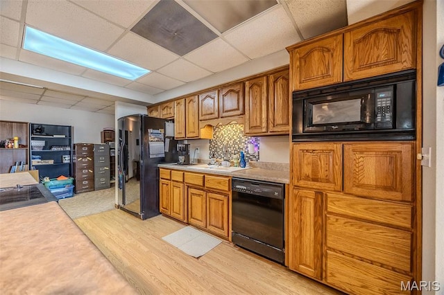 23598 Falcon Rd, Lebanon, MO 65536 - kitchen featuring black appliances, light wood-type flooring, a paneled ceiling, a sink, and brown cabinetry