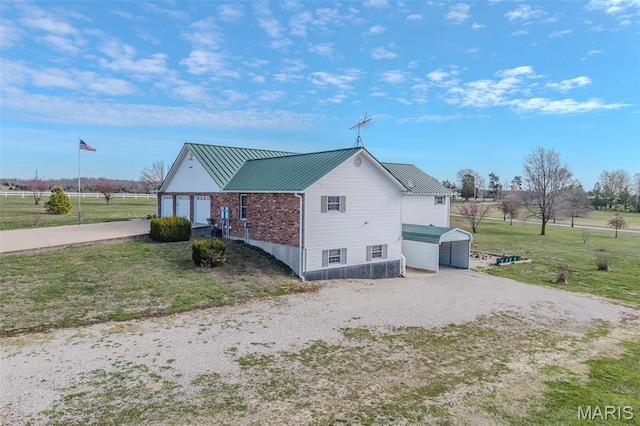 23598 Falcon Rd, Lebanon, MO 65536 - view of home's exterior featuring driveway, metal roof, and a lawn