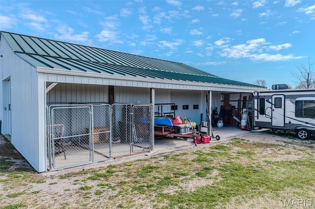23598 Falcon Rd, Lebanon, MO 65536 - rear view of property featuring a standing seam roof, metal roof, an outbuilding, and a detached garage