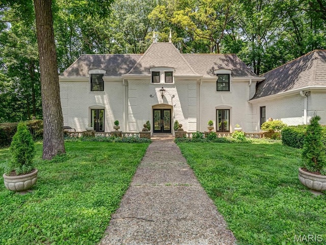 335 N Powder Mill Rd, Belleville, IL 62223 - french country inspired facade with french doors, a front yard, brick siding, and a shingled roof