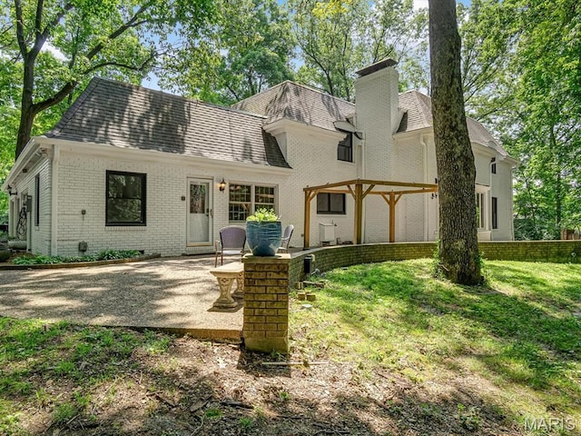 335 N Powder Mill Rd, Belleville, IL 62223 - rear view of house featuring brick siding, a patio area, a chimney, a yard, and roof with shingles