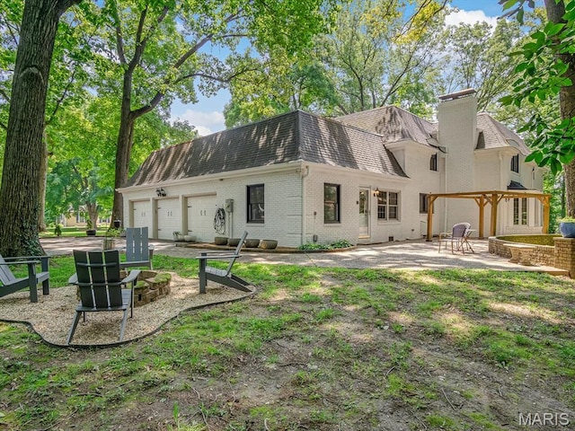 335 N Powder Mill Rd, Belleville, IL 62223 - back of property with brick siding, a chimney, a patio area, an attached garage, and roof with shingles