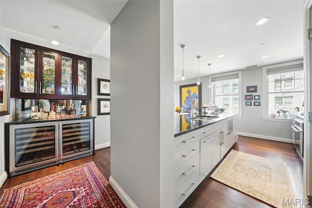 indoor dry bar featuring beverage cooler, baseboards, dark wood finished floors, recessed lighting, and stainless steel oven