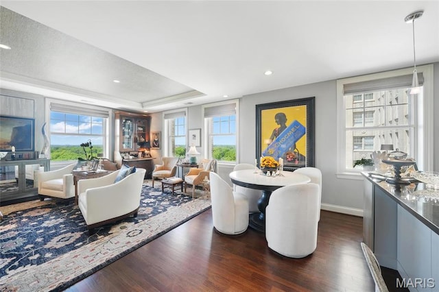 dining area featuring dark wood-type flooring, baseboards, a tray ceiling, and recessed lighting