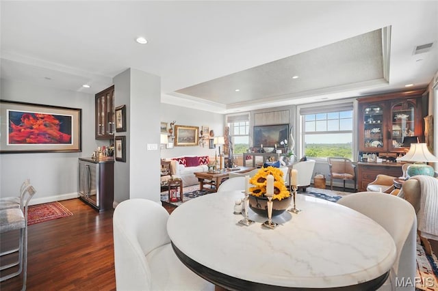 dining room with a tray ceiling, dark wood-style flooring, baseboards, and recessed lighting