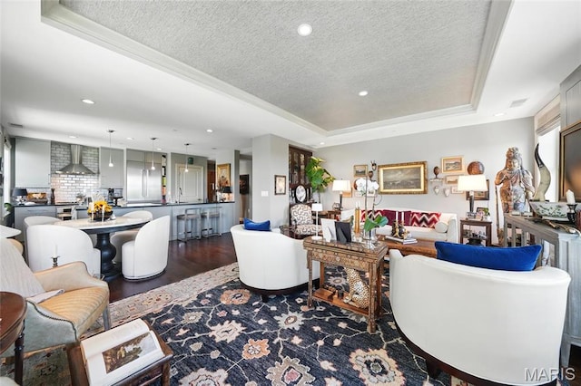 living area with a raised ceiling, a textured ceiling, recessed lighting, and dark wood-type flooring