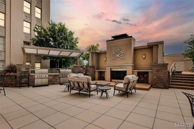 view of patio / terrace featuring an outdoor brick fireplace, area for grilling, and a grill