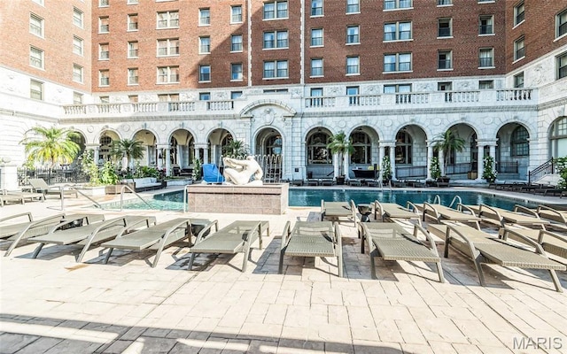 community pool with a patio and outdoor lounge area