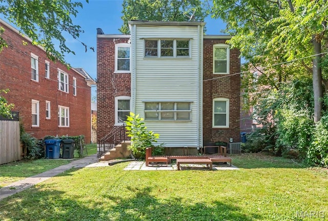 back of property with a lawn and central air condition unit