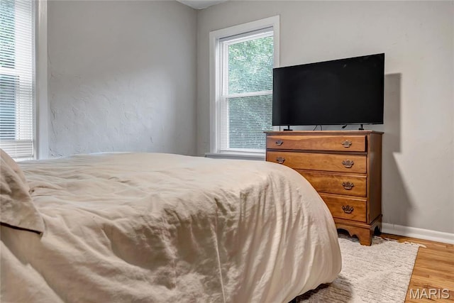 bedroom featuring wood finished floors and baseboards