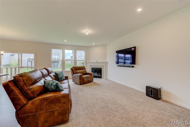 carpeted living area featuring a fireplace with flush hearth, recessed lighting, and baseboards