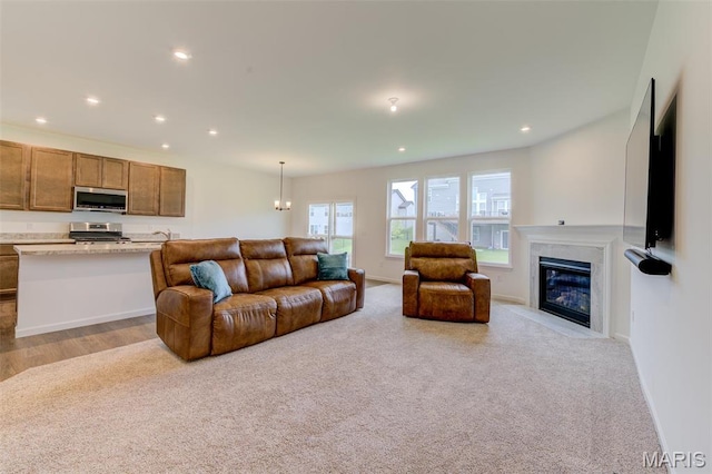 living room featuring recessed lighting, a fireplace with flush hearth, and baseboards