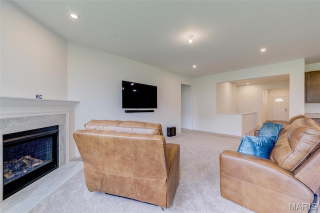 living room featuring light carpet, a high end fireplace, and recessed lighting