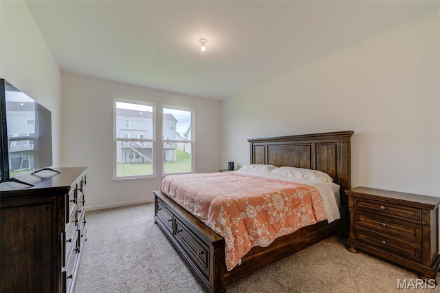 bedroom featuring light carpet and baseboards
