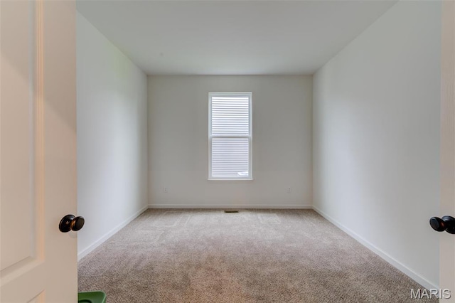unfurnished room with carpet and baseboards