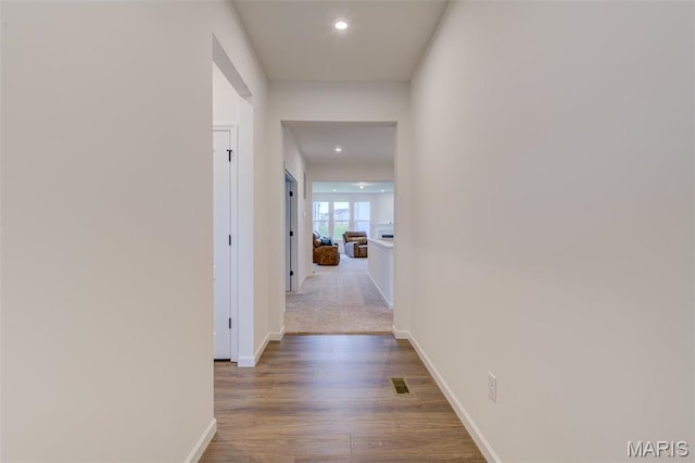 corridor featuring recessed lighting, baseboards, and wood finished floors
