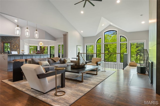 living area with high vaulted ceiling, wood finished floors, and recessed lighting
