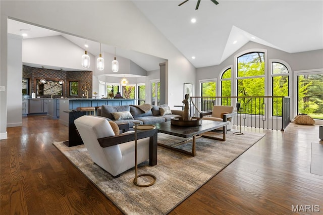 living area with dark wood-style floors, high vaulted ceiling, and recessed lighting