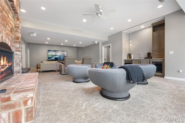living room with a fireplace, light carpet, beverage cooler, a ceiling fan, and recessed lighting