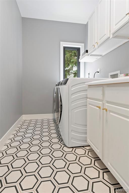 washroom featuring cabinet space, light floors, and baseboards