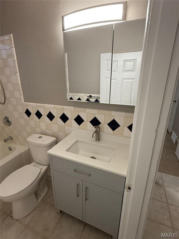 139 Euclid Ave, Saint Louis, MO 63119 - full bath with toilet, vanity, tile walls,  shower combination, and wainscoting