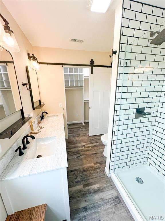 800 E Center St, Salem, MO 65560 - full bath featuring wood finished floors, a stall shower, double vanity, toilet, and a spacious closet