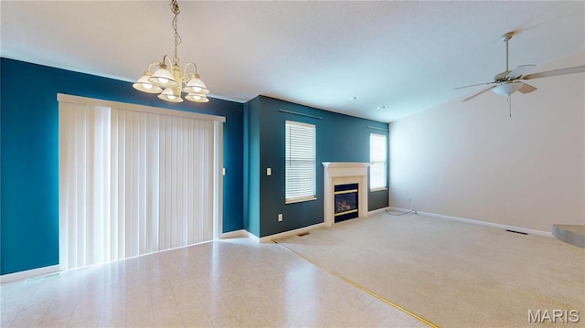unfurnished living room with a chandelier, a ceiling fan, baseboards, and a glass covered fireplace