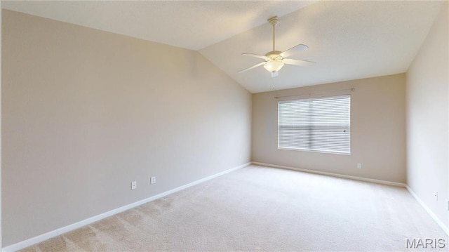 empty room featuring light carpet, a ceiling fan, baseboards, and vaulted ceiling