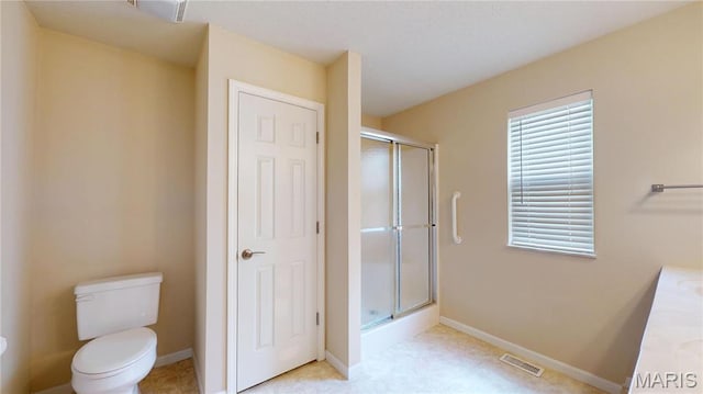 full bathroom featuring a shower stall, toilet, and baseboards