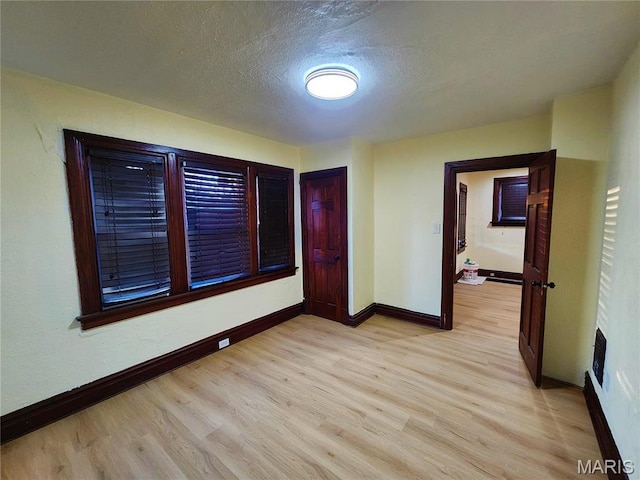 436 Hern Ave, Saint Louis, MO 63135 - unfurnished room with baseboards, light wood-type flooring, and a textured ceiling
