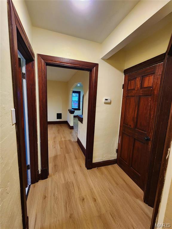 436 Hern Ave, Saint Louis, MO 63135 - corridor with light wood-type flooring, arched walkways, and baseboards