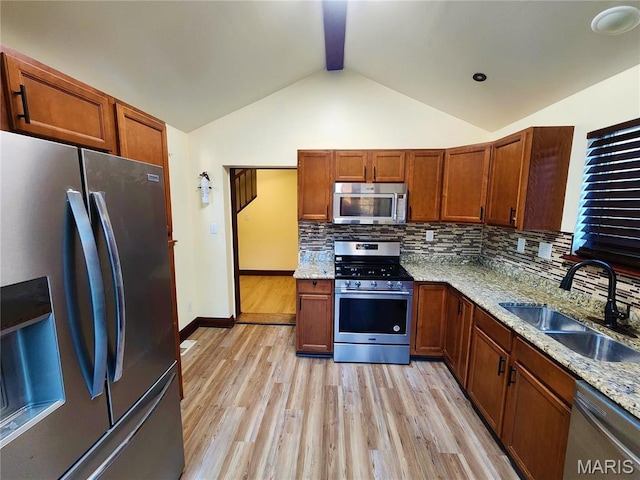 436 Hern Ave, Saint Louis, MO 63135 - kitchen featuring stainless steel appliances, a sink, light wood finished floors, vaulted ceiling, and backsplash