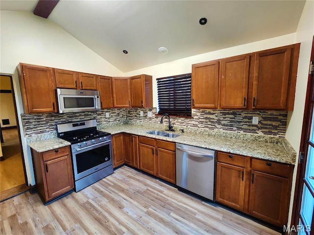 436 Hern Ave, Saint Louis, MO 63135 - kitchen featuring appliances with stainless steel finishes, a sink, lofted ceiling, brown cabinets, and decorative backsplash