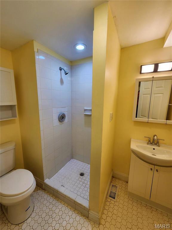 436 Hern Ave, Saint Louis, MO 63135 - full bath featuring toilet, tiled shower, vanity, baseboards, and recessed lighting