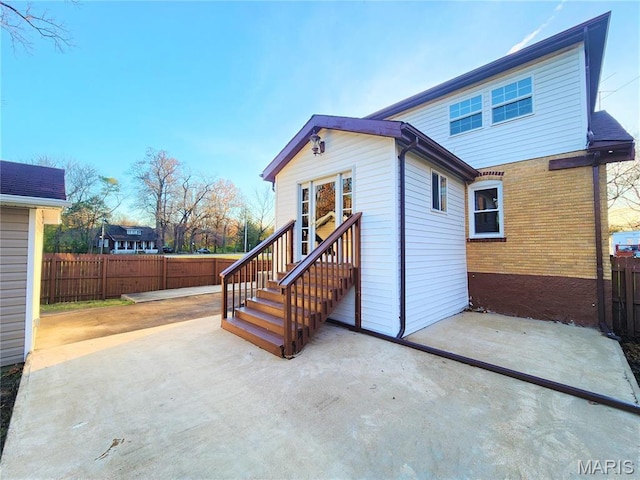 436 Hern Ave, Saint Louis, MO 63135 - rear view of property featuring fence, a patio area, brick siding, and entry steps