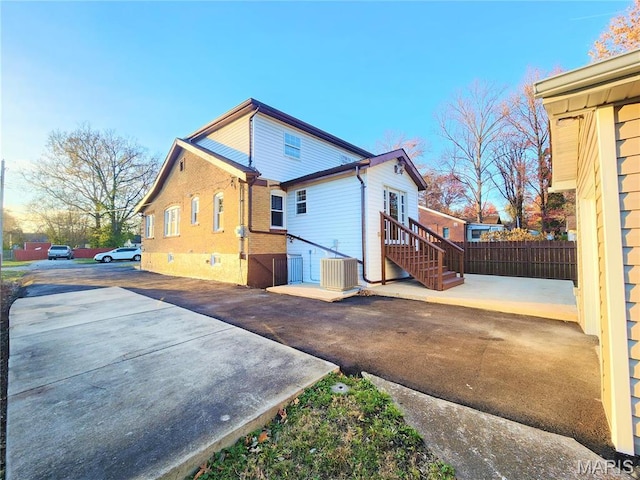 436 Hern Ave, Saint Louis, MO 63135 - rear view of property featuring cooling unit, fence, and brick siding