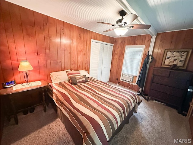 carpeted bedroom featuring wooden walls, a ceiling fan, a closet, and cooling unit