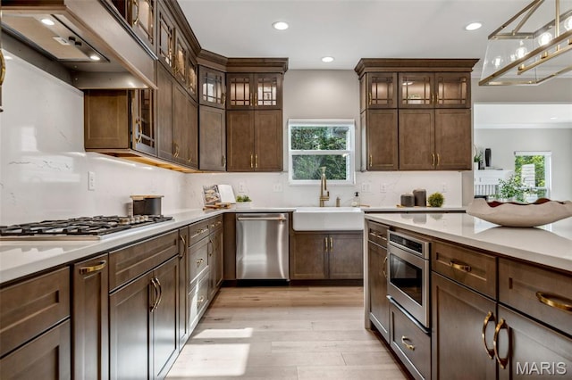 973 Tara Ct, Chesterfield, MO 63005 - kitchen with appliances with stainless steel finishes, premium range hood, light wood finished floors, light countertops, and recessed lighting
