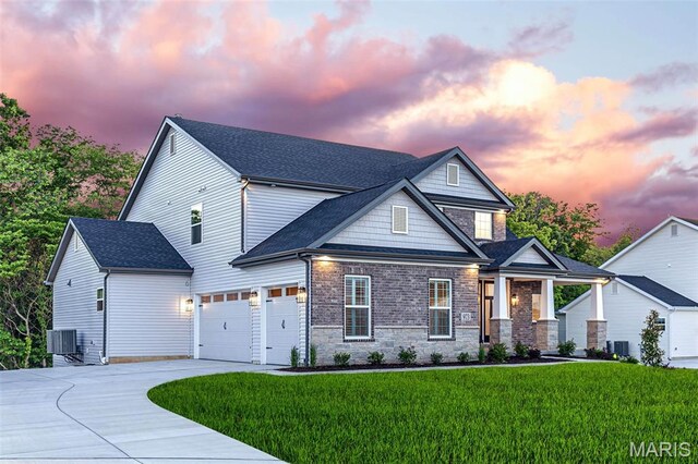 973 Tara Ct, Chesterfield, MO 63005 - craftsman house featuring concrete driveway, a lawn, stone siding, a garage, and roof with shingles
