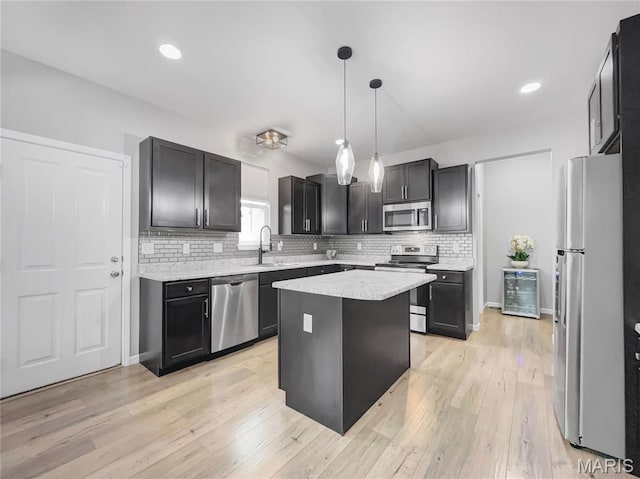 3242 Camp St, Saint Charles, MO 63301 - kitchen featuring stainless steel appliances, decorative backsplash, light countertops, a sink, and a kitchen island