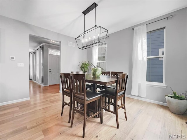 3242 Camp St, Saint Charles, MO 63301 - dining space with light wood finished floors, a chandelier, and baseboards