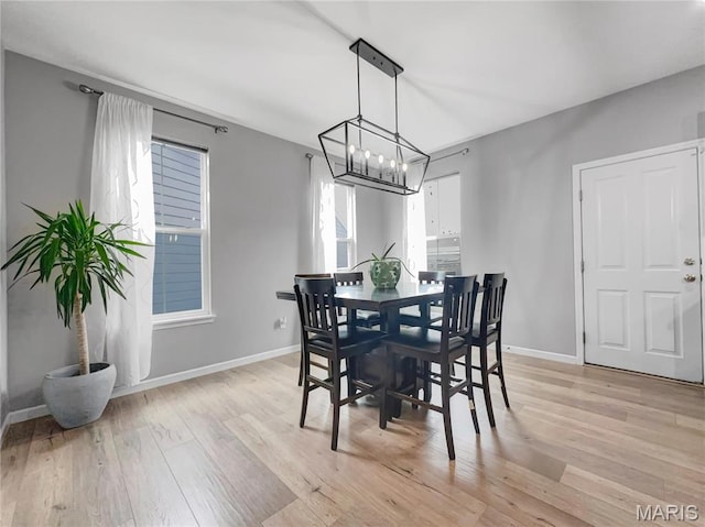 3242 Camp St, Saint Charles, MO 63301 - dining area with light wood-type flooring, baseboards, and a chandelier