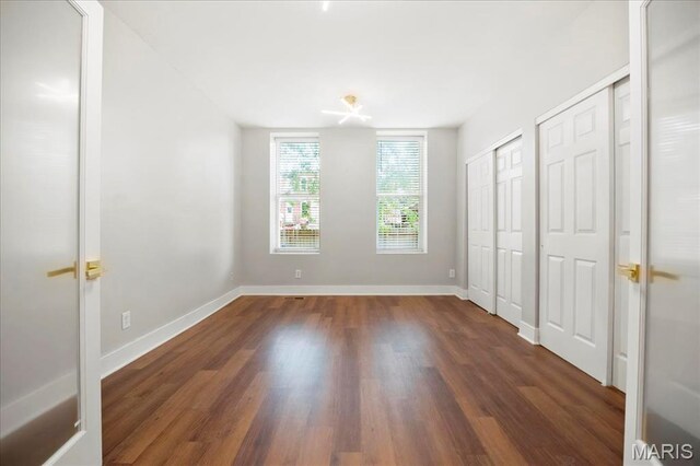 3431 California Ave, Saint Louis, MO 63118 - unfurnished bedroom with multiple closets, wood finished floors, and baseboards