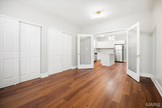 3431 California Ave, Saint Louis, MO 63118 - unfurnished bedroom with freestanding refrigerator, two closets, baseboards, and dark wood-type flooring