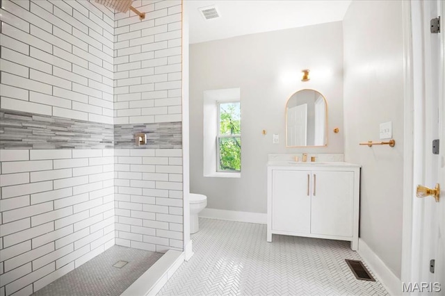 3431 California Ave, Saint Louis, MO 63118 - bathroom featuring tiled shower, vanity, toilet, tile patterned floors, and baseboards