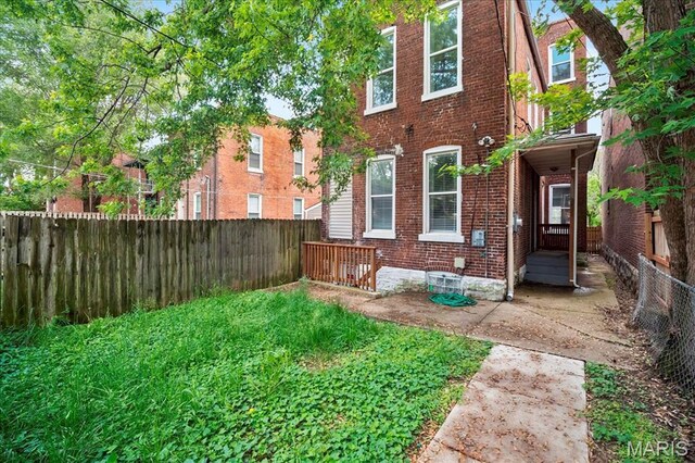 3431 California Ave, Saint Louis, MO 63118 - rear view of house with brick siding and a fenced backyard