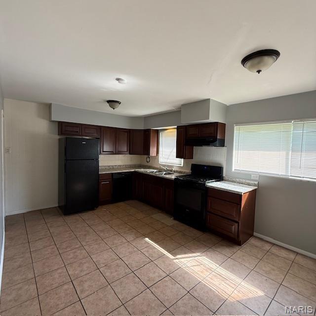 9732 Glen Owen Dr, Saint Louis, MO 63136 - kitchen featuring black appliances, plenty of natural light, light tile patterned floors, and light countertops