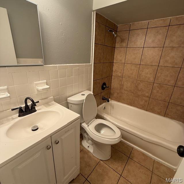 9732 Glen Owen Dr, Saint Louis, MO 63136 - full bath featuring toilet, tile patterned floors, tile walls,  shower combination, and vanity
