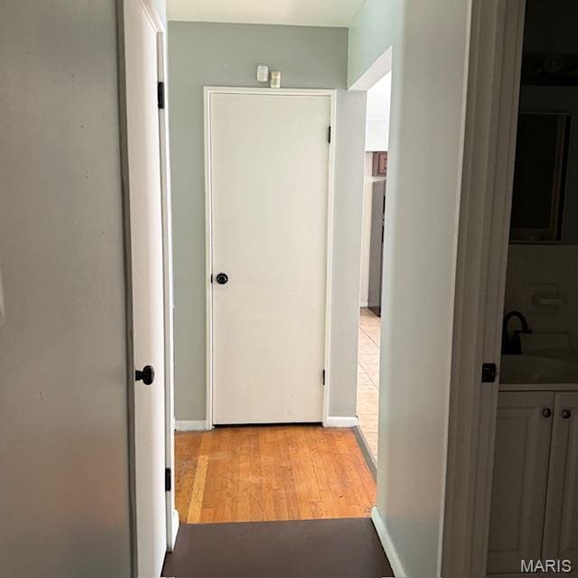 9732 Glen Owen Dr, Saint Louis, MO 63136 - hall with a sink, light wood-type flooring, and baseboards